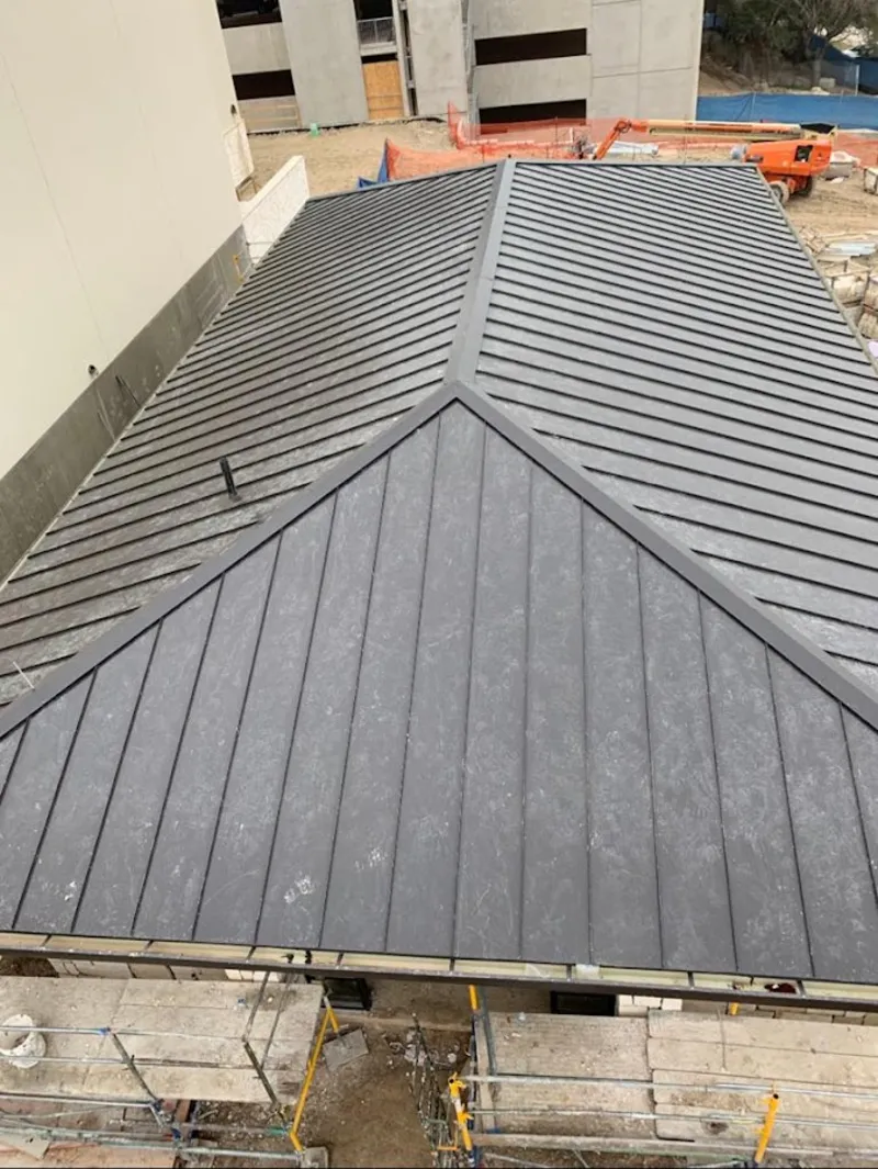 Commercial metal roof construction with crane equipment in Middle